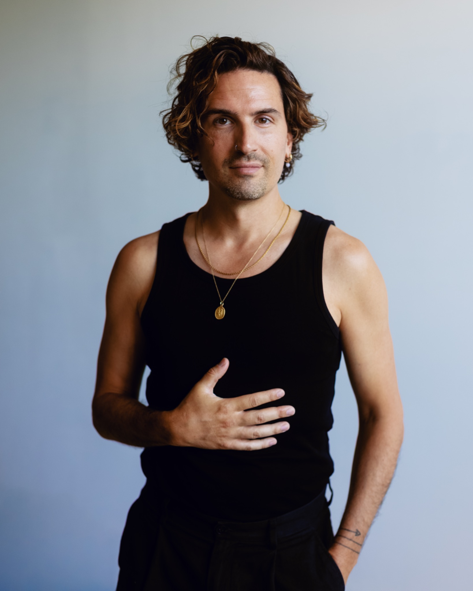 Portrait de Marco, une main posée sur le torse et le regard vers l’objectif.