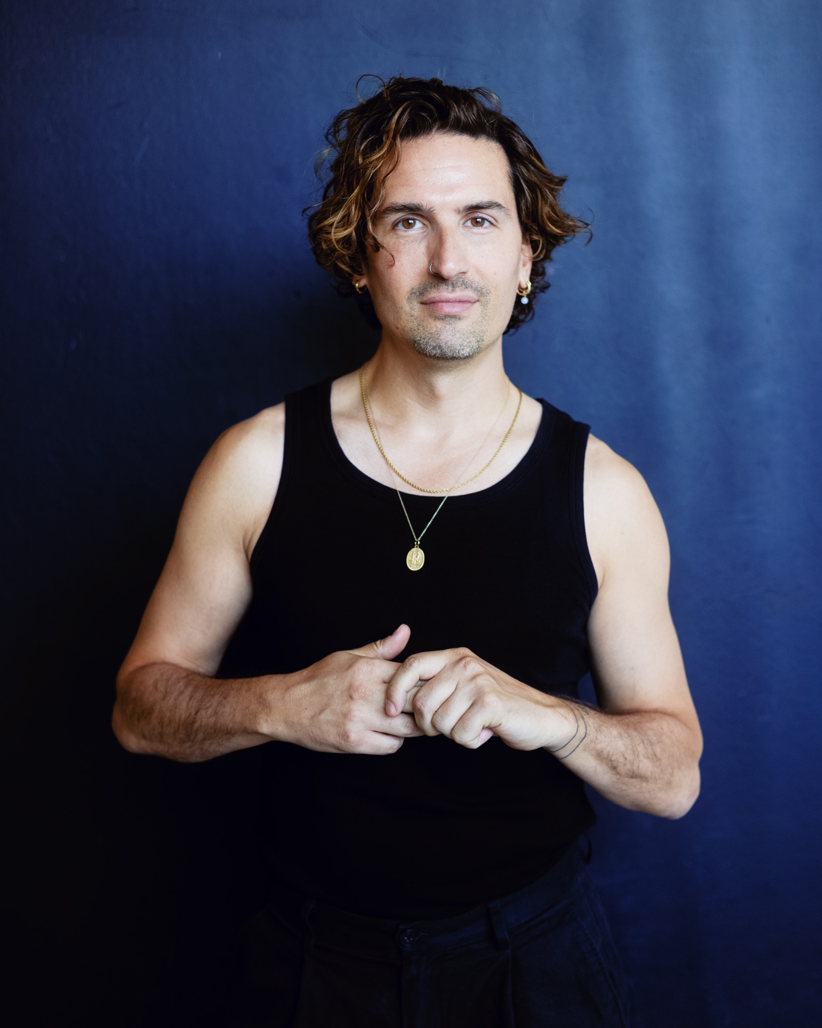 Portrait de Marco, les mains réunies devant lui.